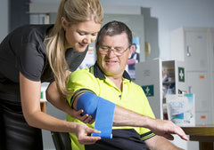 nurse putting CoolXChange compression wrap on guys elbow